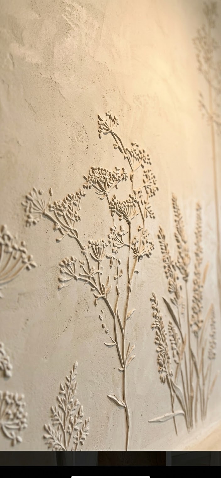 Close detail of raised botanical relief in Marmorino fireplace finish