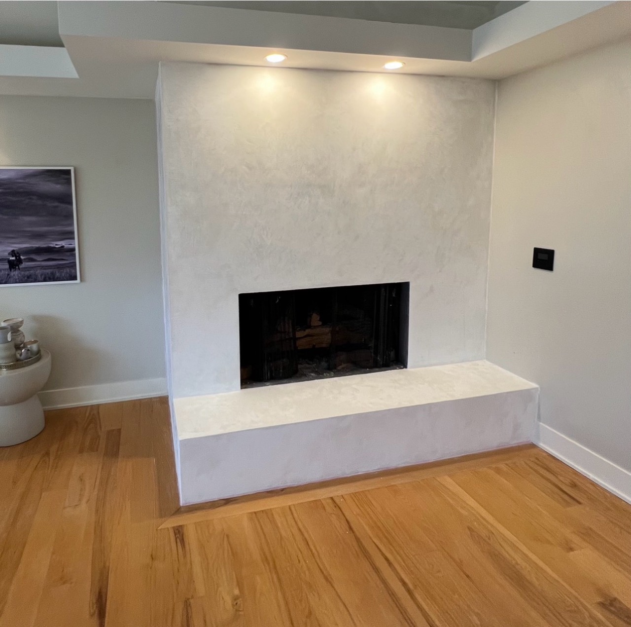 Frontal view of a finished light Marmorino fireplace in West Vancouver
