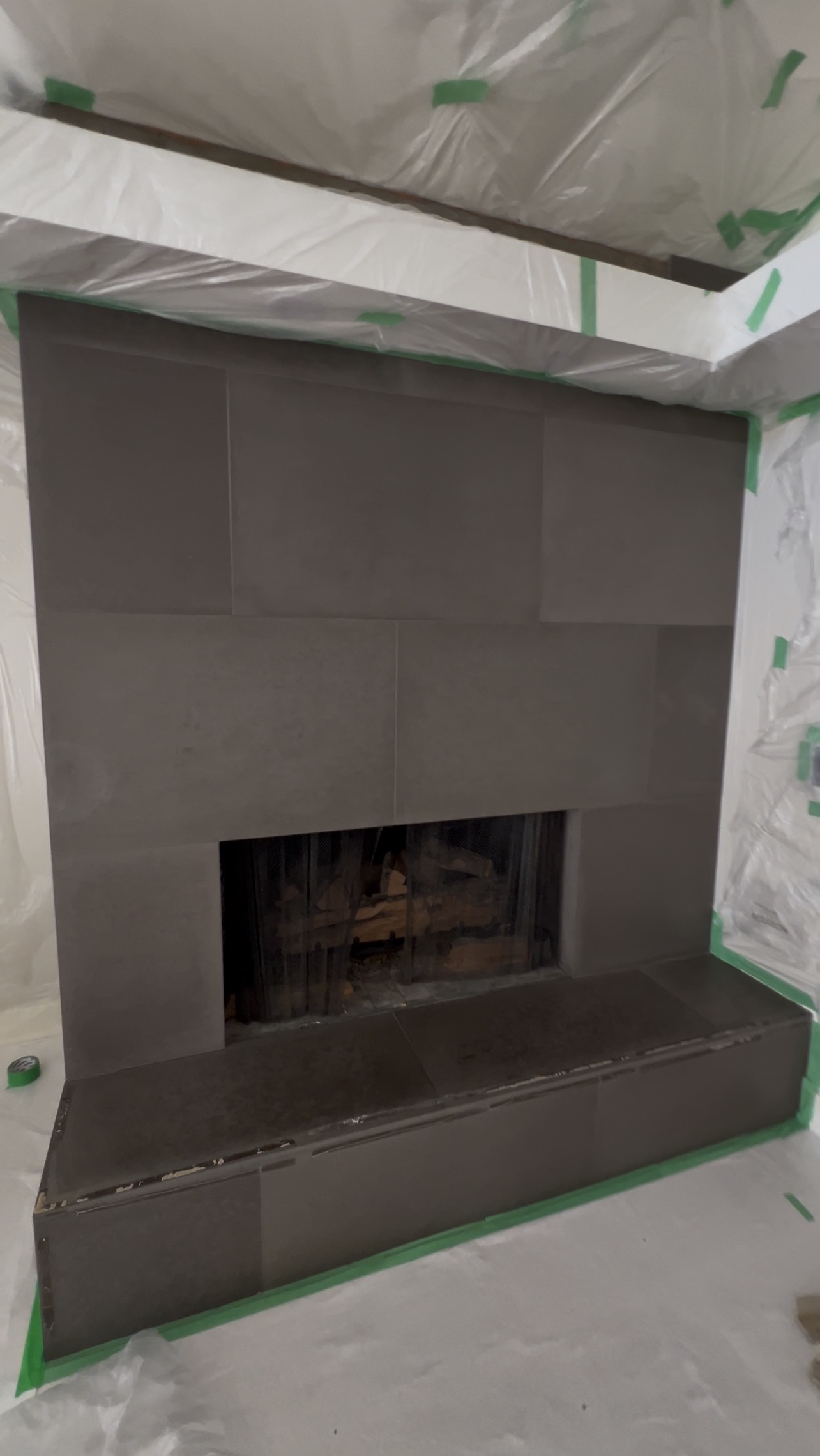 Before view of dark large-format tiled fireplace in West Vancouver